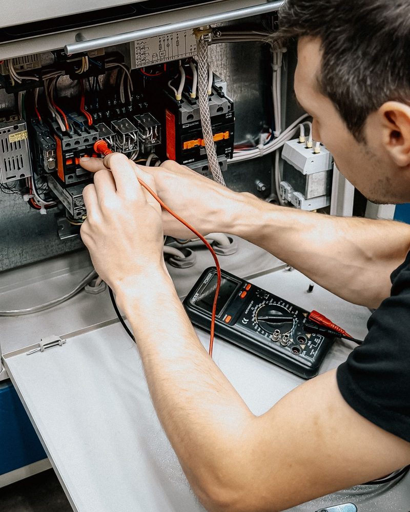 Elektriker misst mit dem Multimeter an einer Unterverteilung