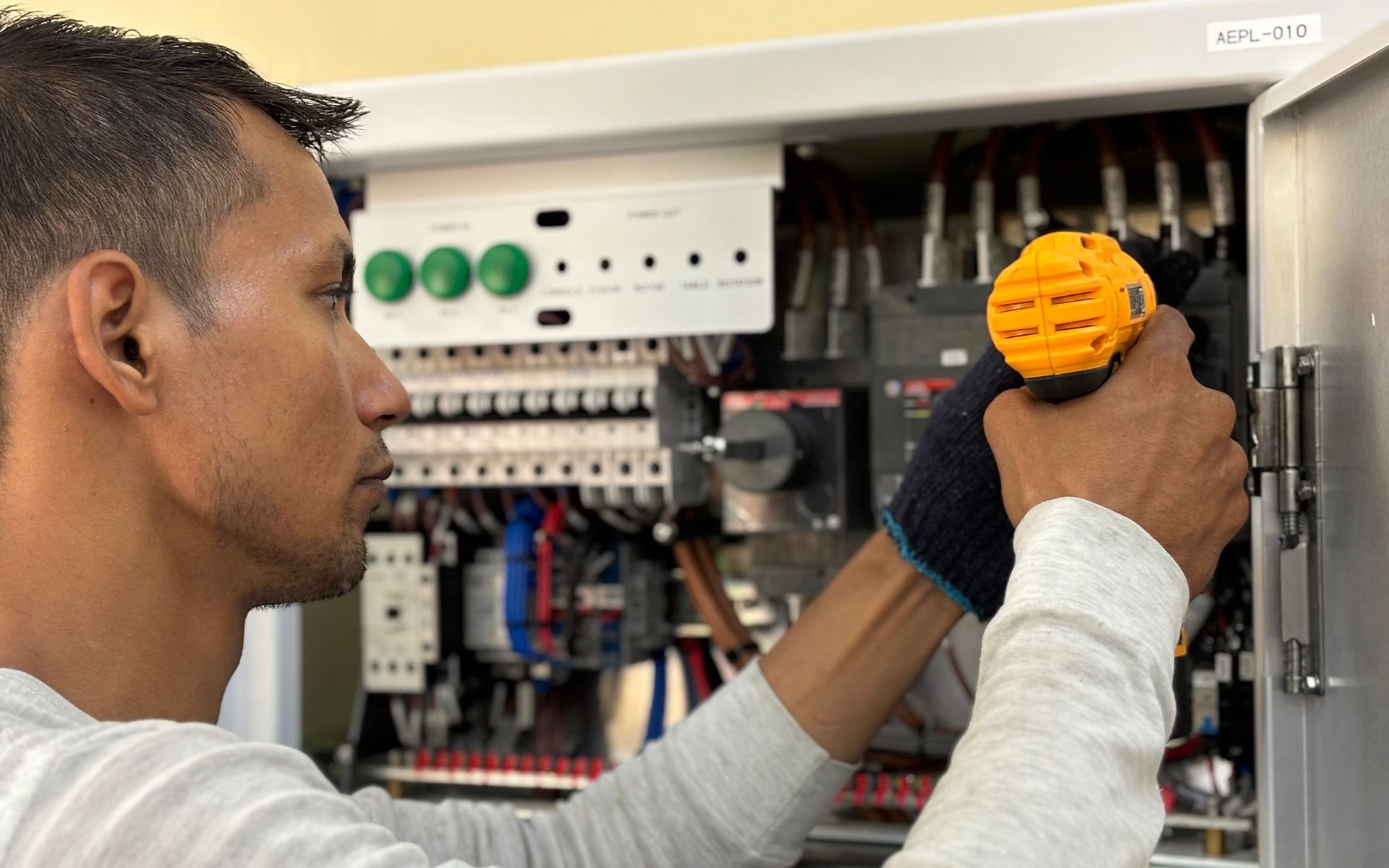 Elektriker arbeitet konzentriert am geöffneten Sicherungskasten
